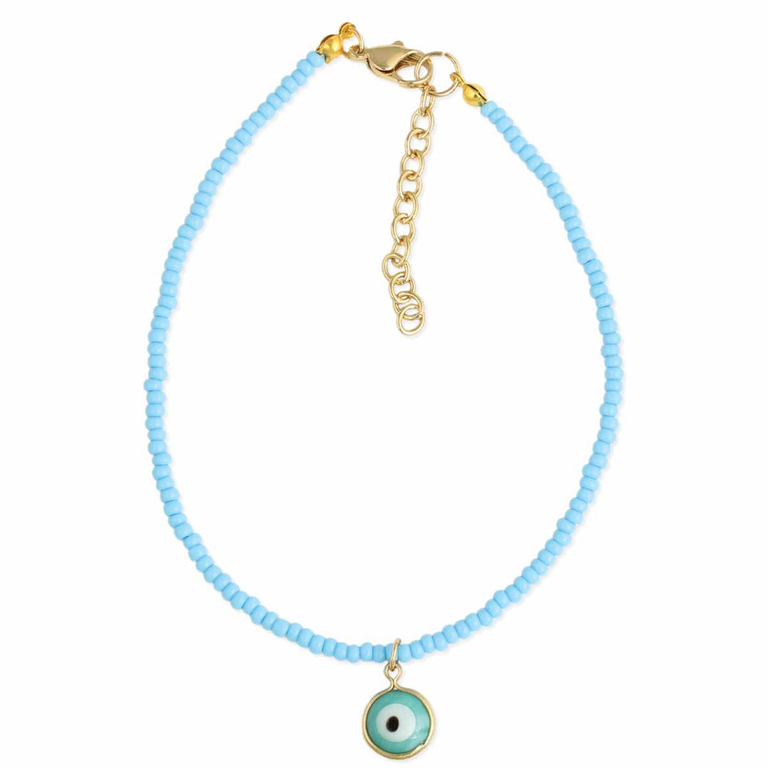 The Watchful Blue Eye Anklet by ZAD Jewelry features small light blue beads, a gold lobster clasp with adjustable chain, and a central round evil eye charm in blue, white, and black.