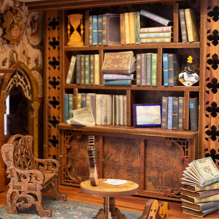 The Hands Craft DIY Book Nook Kit: Eternal Bookstore with Dust Cover features wooden shelves of colorful books, a carved chair, small table, two mini guitars, and a book stack—an ideal literary gift for any reader.