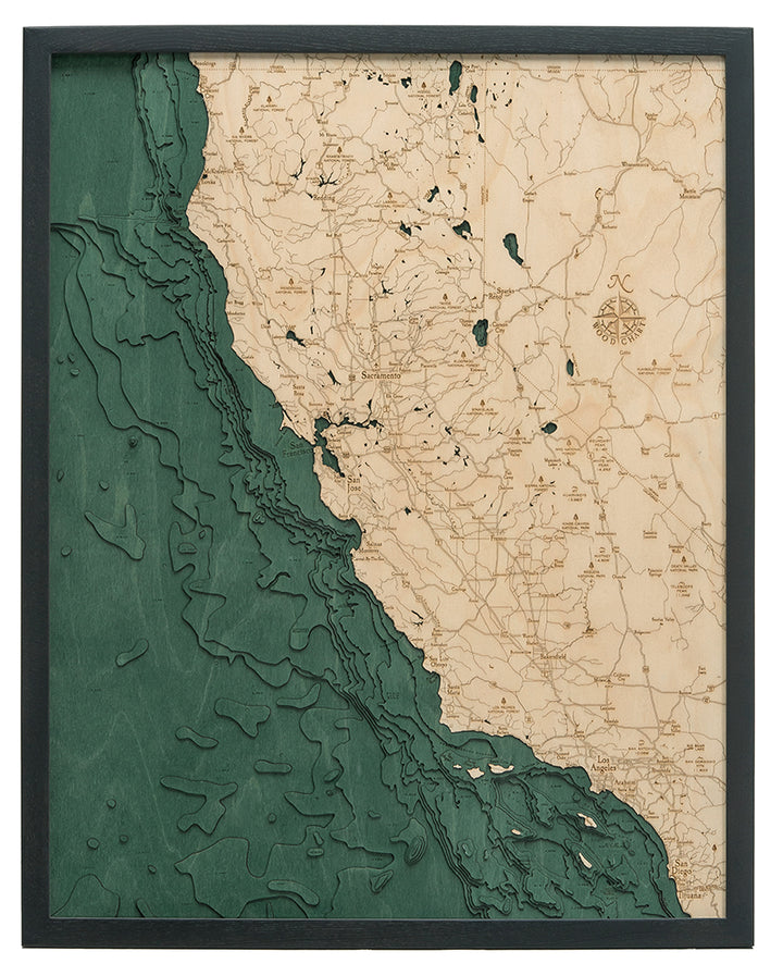The WoodChart California Coast 24.5" x 31" map features the state's coastline and inland areas in natural wood and green ocean, with major cities, roads, and features etched into the land. It comes in a sleek black frame.