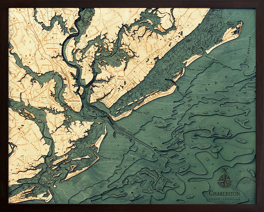 The WoodChart CharlstonSC 24.5 x 31 Black Frame features an artistic map of Charleston, SC, highlighting rivers, islands, land elevations, and coasts in tan and green tones with a decorative compass rose at the bottom right.