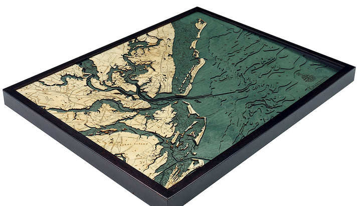 The WoodChart CharlstonSC 24.5 x 31 Black Frame is a framed, 3D layered wooden map in beige and green, displaying detailed land contours and waterways with a textured surface.