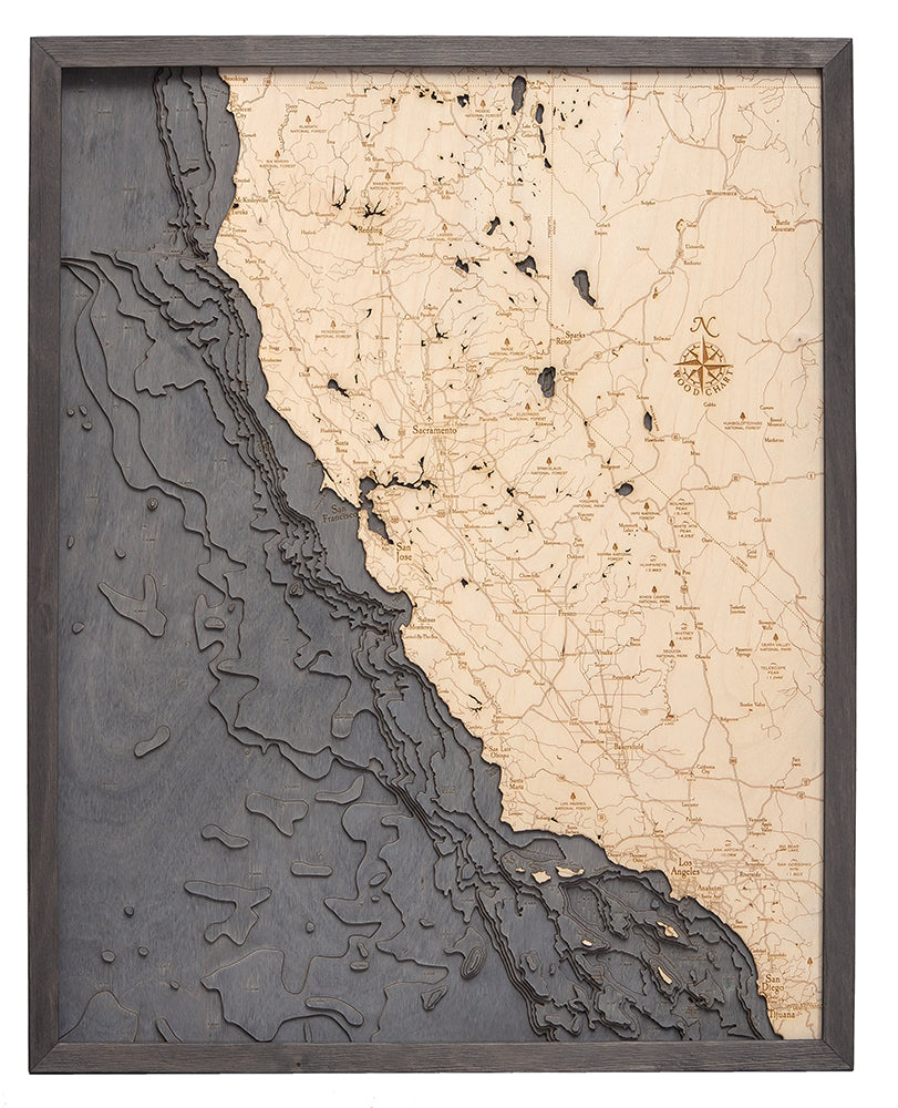 The WoodChart California Coast map (24.5" x 31", Grey Frame) is a framed, laser-cut wooden artwork featuring detailed topography, roads, cities, and the Pacific Ocean.
