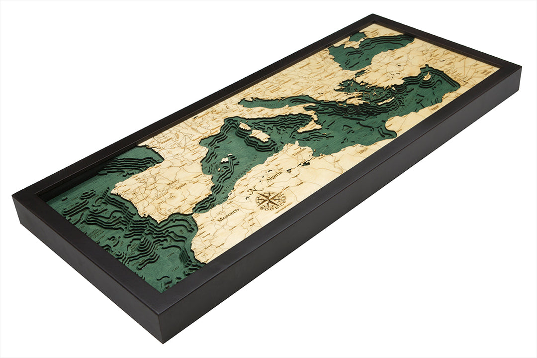 The WoodChart Mediterranean Sea 13.5" x 31" Black Frame map features a topographic, layered wood design with green water, highlighting Europe, North Africa, and the Middle East.