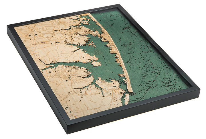 The WoodChart Ocean City MD 24.5 x 31 Black Frame is a layered wooden map featuring coastal land in light wood with engraved roads and towns, and water depicted in multiple green shades.