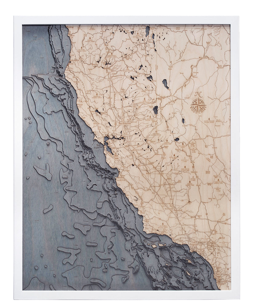 The WoodChart California Coast 24.5" x 31" map features laser-engraved roads, cities, and topography on natural wood land, with a blue-gray stained ocean, all set in a white frame.