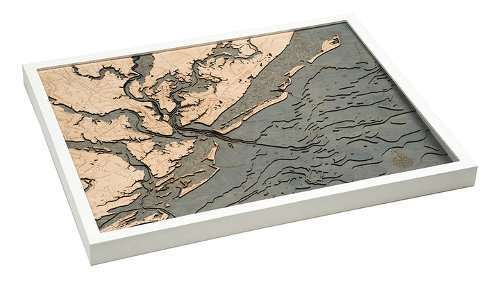 The WoodChart CharlstonSC 24.5 x 31 White Frame is a layered wooden map featuring detailed rivers, islands, and shoreline contours of the coast in beige and gray tones, all presented in an elegant white frame.