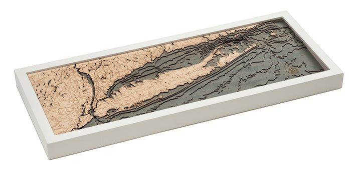 The WoodChart Long Island Sound 13.5" x 31" White Frame is a rectangular, layered wooden map featuring carved contours of the island and water in contrasting light and dark wood tones with detailed topography.