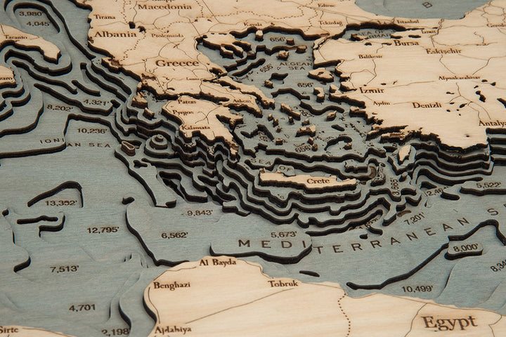 The WoodChart Mediterranean Sea 13.5" x 31" White Frame is a detailed wooden map featuring layered contours of Greece, Albania, Turkey, Egypt, and nearby seas to illustrate land elevation and sea depth.