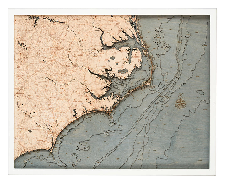 The WoodChart North Carolina Coast 24.5" x 31" White Frame features a vintage-inspired map of the NC coast and inland areas with roads, rivers, Atlantic Ocean, and intricate topographic and nautical details.