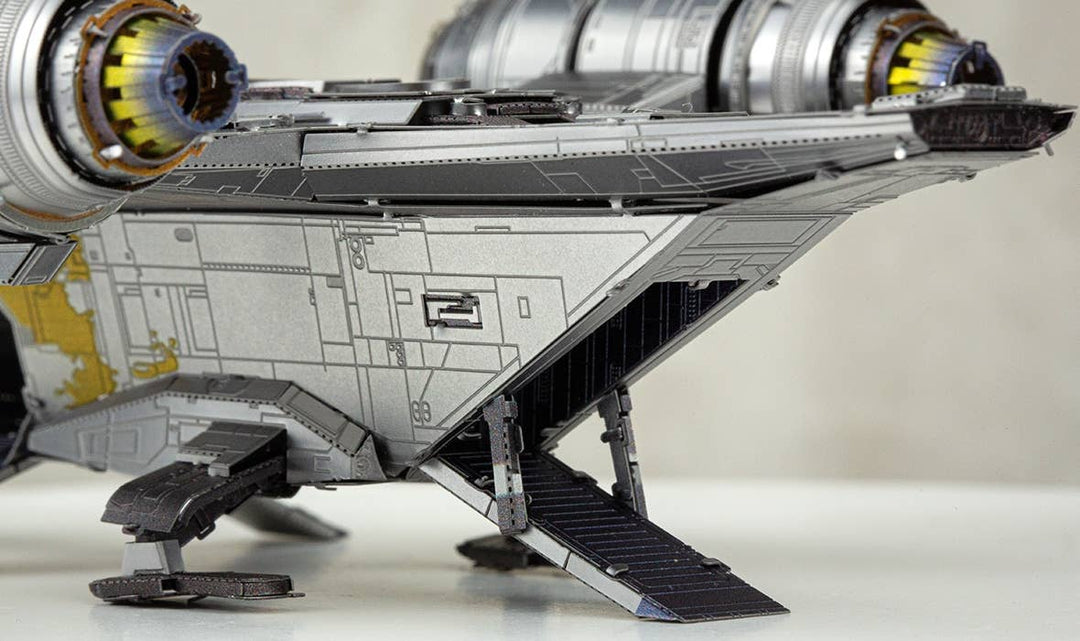 Close-up of the Mandalorian Razor Crest Star Wars Premium Metal Earth DIY by Metal Earth, featuring metallic textures, two large engines, and an extended boarding ramp. The soft-focus background highlights this impressive collector’s kit.