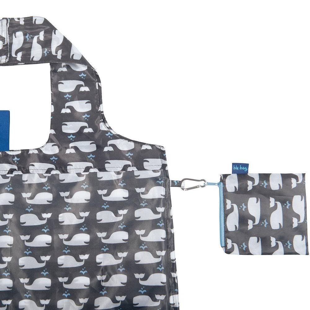 Introducing the Whales Reusable Bag by zzzRockFlowerPaper: a gray shopping bag adorned with an ocean-inspired design of white whales. This eco-friendly bag includes a handy small matching pouch that attaches conveniently with a metal clip. It features a square cut-out handle, ideal for sustainable shopping solutions.