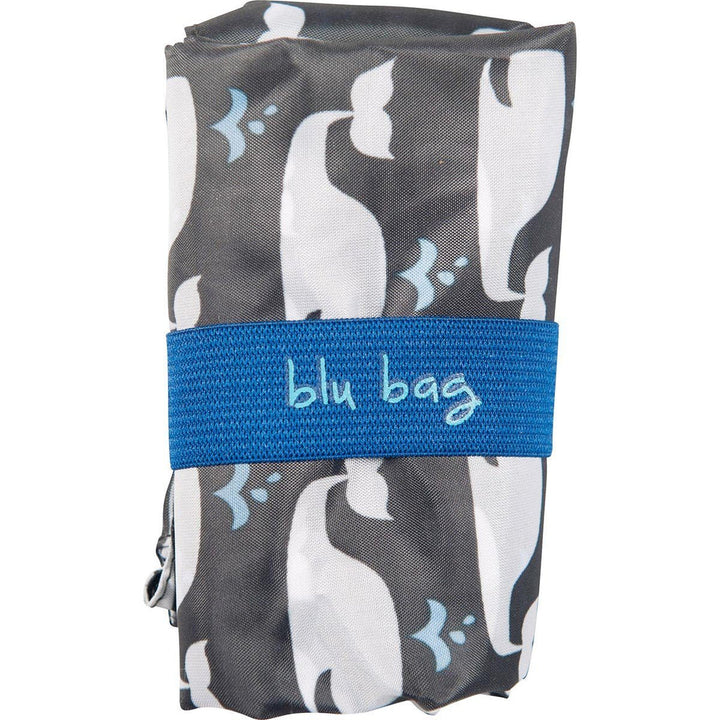The Whales Reusable Bag by zzzRockFlowerPaper, featuring an ocean-inspired print of white and black whales and secured with a blue "blu bag" elastic band, supports Ocean Conservancy efforts.
