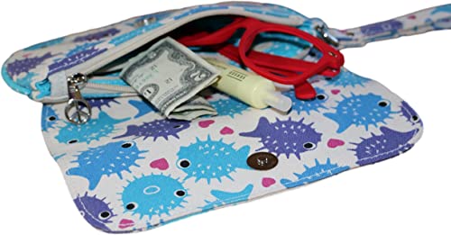 The Large Wristlet Puffer Fish by Bungalow 360 is crafted from cotton canvas, featuring an eye-catching blue and purple fish pattern. Inside, you'll discover red glasses, a folded dollar bill, and a tube of lotion. The wristlet includes a handy strap and a metallic peace sign charm on the zipper pull, making it an ideal choice for fans of distinctive designs.