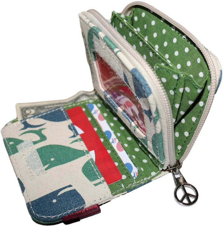 The Bungalow 360 Bill Fold Wallet Whale is a small open wallet featuring a green polka-dot interior and peace sign zipper pull. With unique designs, it offers multiple card compartments, a clear ID slot, and an adorable whale print exterior, ideal for animal cause enthusiasts.