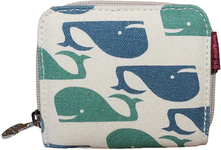 The Bungalow 360 Bill Fold Wallet Whale is a square fabric wallet with a zipper, showcasing green and blue whales on a cream background, plus a small red tag with white text supporting animal causes.