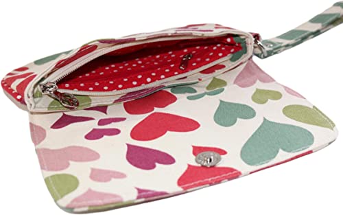 The Bungalow 360 Large Wristlet Hearts showcases unique designs with a variety of colored hearts on a cotton canvas exterior. It opens to reveal a main compartment lined with red fabric and adorned with white polka dots. The wristlet features a silver snap closure and zipper, accented by small metallic details.