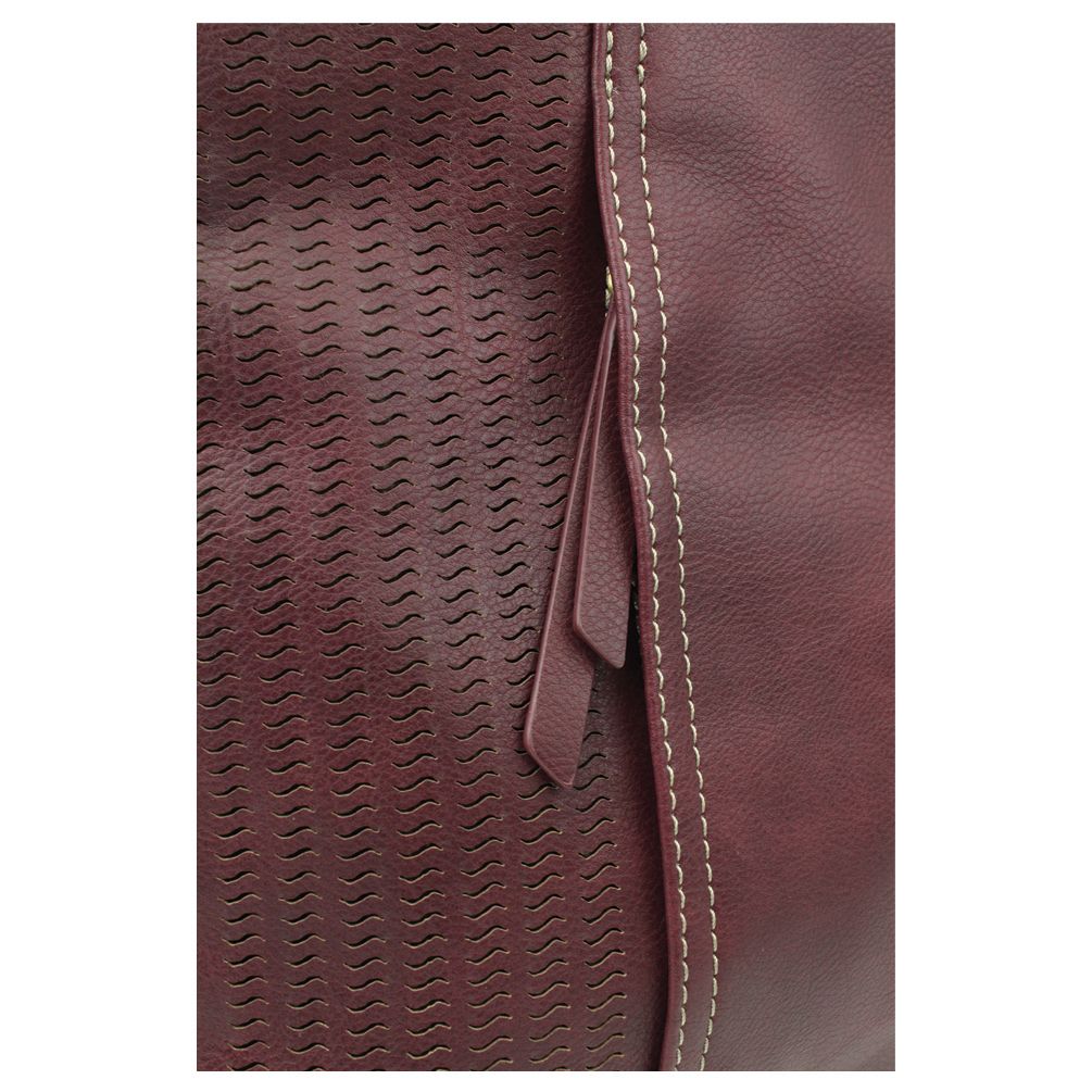Close-up of textured faux plum leather from the Lasercut Crossbody DF by Chala, featuring a wavy laser-cut pattern on the left and a smooth surface on the right. A vertical seam with contrasting white stitching runs along the edge, adorned with a leather loop detail.