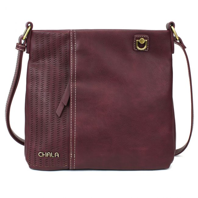 The Lasercut Crossbody DF in plum, designed by Chala, is crafted from faux leather with a textured panel on the left and a smooth panel on the right. It features an adjustable shoulder strap and is accented by a gold-tone clasp on the top right. The brand name "Chala" shimmers in gold on the bottom left.