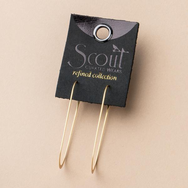 A pair of large, thin, gold hoop earrings is displayed on a black card labeled "Scout Jewelry Cosmic Oval Silver." Crafted from 925 Sterling Silver and hypoallergenic materials, these earrings are nickel and cadmium free. The card has a circular cutout at the top and is set against a light beige background.