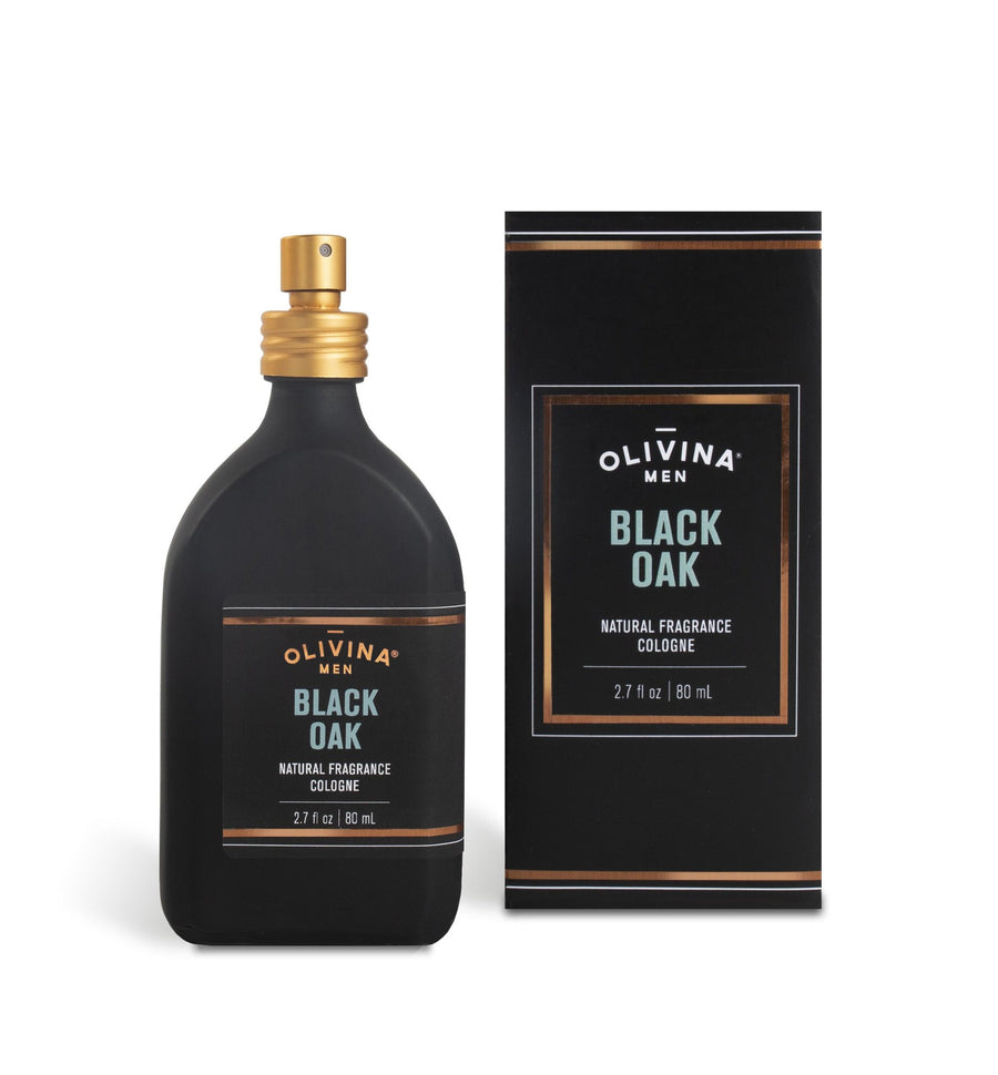 A bottle and a box of Barrel and Oak's Black Oak Cologne, infused with natural essential oils, are displayed. The black bottle with a gold cap enhances the earthy warm oak scent, while the matching box echoes the sleek design. The cologne is measured at 2.7 fl oz (80 ml).