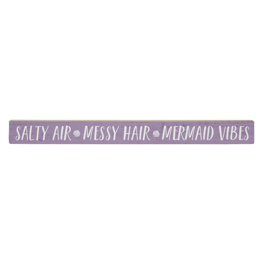 A long, handcrafted purple wooden SincereSurroundings Salty Air sign features "SALTY AIR • MESSY HAIR • MERMAID VIBES" with shell icons between phrases. Complements any wood shelf with its white finish.