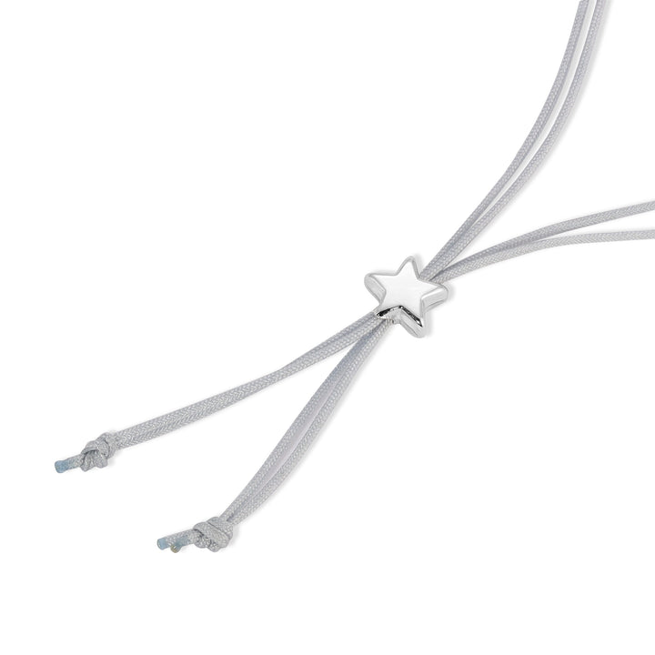The Moon Phase Bracelet Silver by LuckyFeather features a silver cord threaded through a sleek, minimalist charm shaped like a star at its center. The bracelet has two adjustable ends, each finishing in a knot. Its simple design highlights the shiny metal star, making it an attractive piece for astrological enthusiasts. The background is plain white.