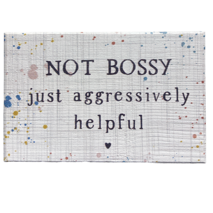 The "Not Bossy" sign by SincereSurroundings features a white wood texture adorned with colorful splatters, and displays the phrase "NOT BOSSY just aggressively helpful" with a small heart beneath the text. This delightful piece is perfect for easy display and adds a touch of whimsy to any space.