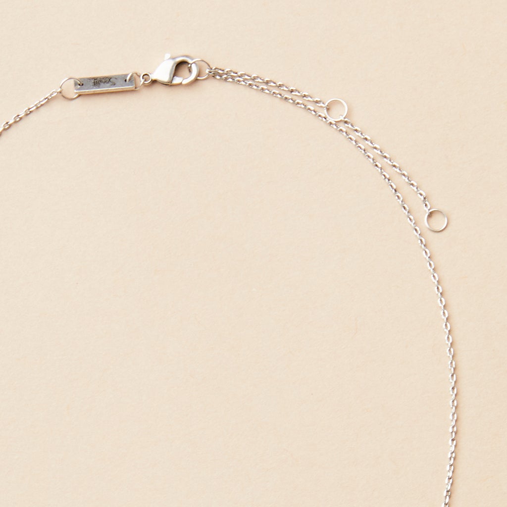 The Refined Neck Comet/Silver by Scout Jewelry, featuring a lobster clasp and extender rings, elegantly adorns a neutral background.