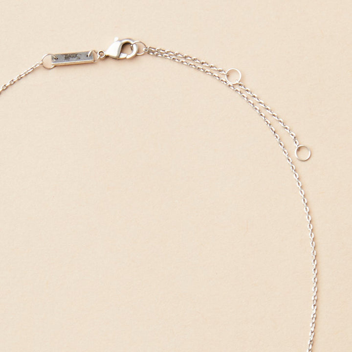 The Refined Neck Comet/Silver by Scout Jewelry, featuring a lobster clasp and extender rings, elegantly adorns a neutral background.