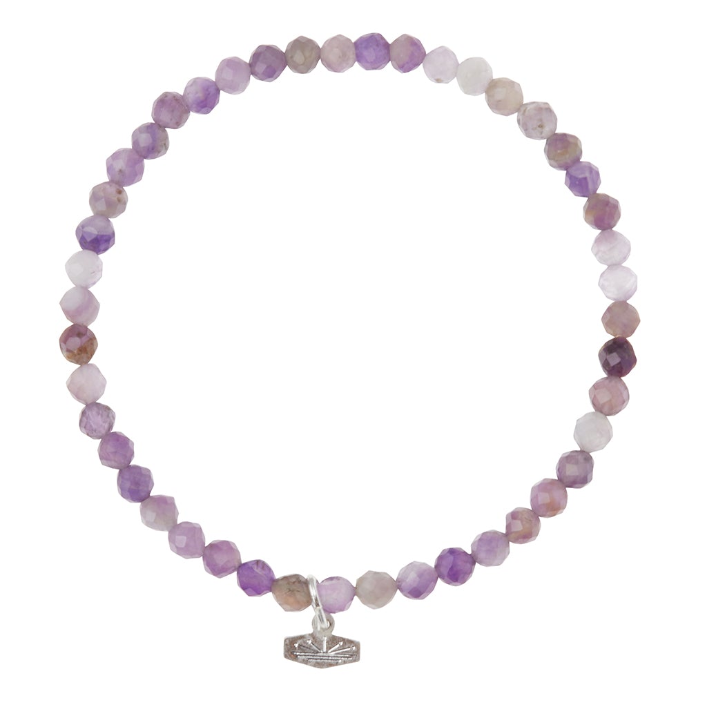 Introducing the Mini Bracelet Amethyst/Silver by Scout Jewelry: a stunning piece featuring faceted purple and white semi-precious gemstone beads, beautifully complemented with a delicate silver lotus charm.