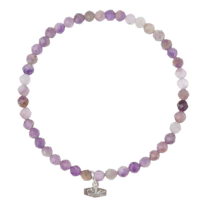 Introducing the Mini Bracelet Amethyst/Silver by Scout Jewelry: a stunning piece featuring faceted purple and white semi-precious gemstone beads, beautifully complemented with a delicate silver lotus charm.