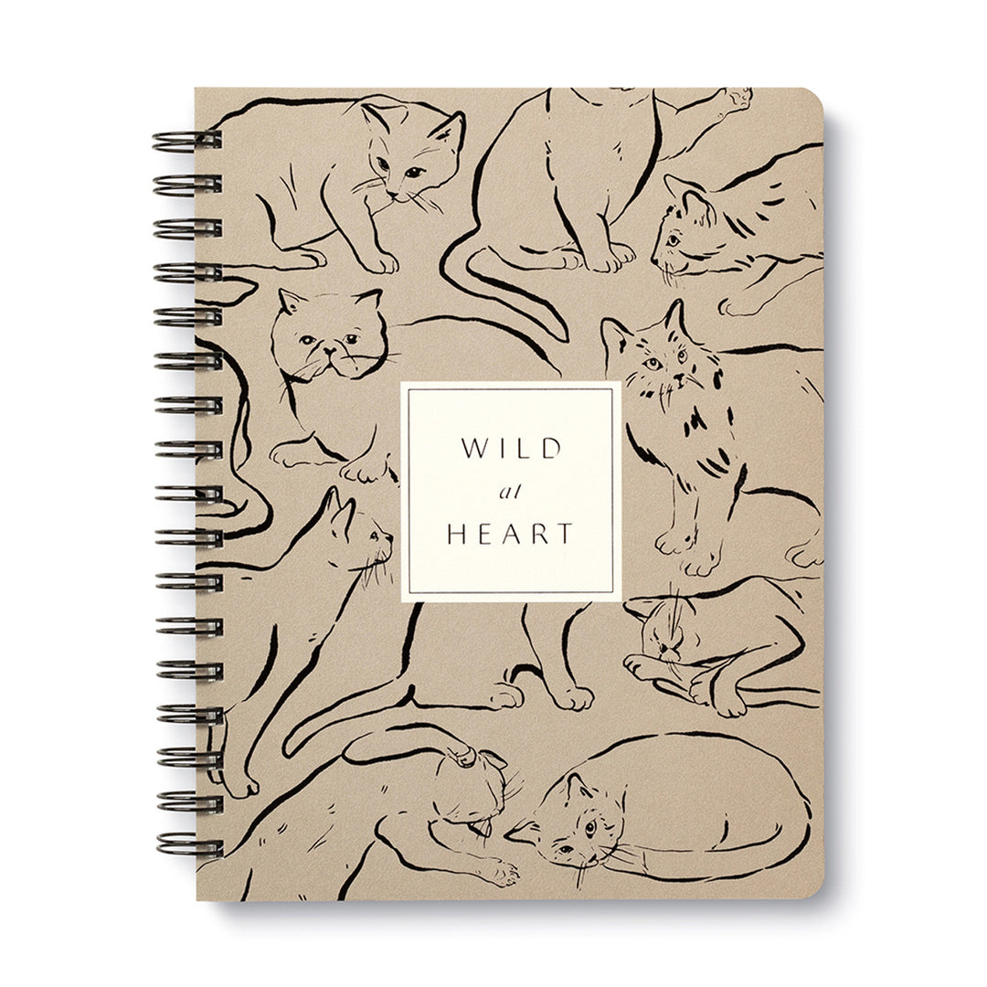 The Wild at Heart Spiral Notebook by Compendium features a beige cover adorned with numerous cat illustrations in various poses. At the center, a white square showcases the text "WILD at HEART" in elegant black font, making it an ideal choice for animal lovers.
