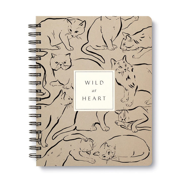The Wild at Heart Spiral Notebook by Compendium features a beige cover adorned with numerous cat illustrations in various poses. At the center, a white square showcases the text "WILD at HEART" in elegant black font, making it an ideal choice for animal lovers.