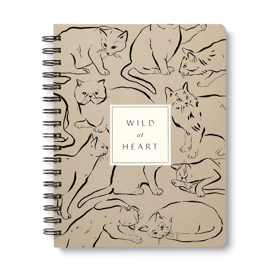 The Wild at Heart Spiral Notebook by Compendium features a beige cover adorned with numerous cat illustrations in various poses. At the center, a white square showcases the text "WILD at HEART" in elegant black font, making it an ideal choice for animal lovers.