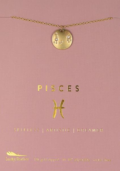 A delicate LuckyFeather Zodiac Necklace Pisces with a gold pendant featuring the Pisces zodiac sign is displayed against a light pink background. The card reads "Pisces" along with the words "Selfless | Artistic | Dreamer" and details of "14k gold dipped" and "16-18" adjustable - necklace.