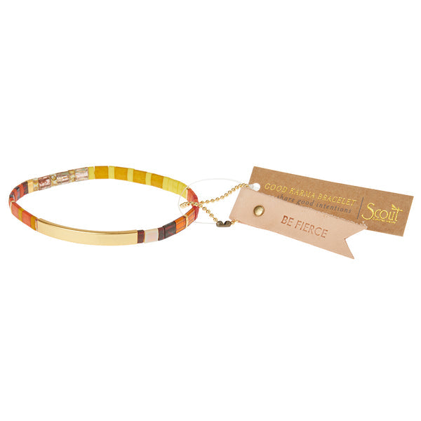 The Miyuki Be Fierce Sunset Gold bracelet by Scout Jewelry is a multicolored piece with a 14K gold dipped bar, attached to a brown tag reading "Good Karma Bracelet" and "BE FIERCE," perfect for those seeking empowering messages.