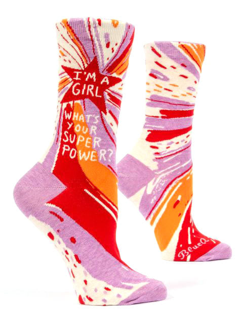 The Girl Superpower Socks by Blue Q are colorful socks featuring an abstract design in shades of purple, red, orange, and white. Crafted from nylon and combed cotton, these socks boast the bold white text "I'M A GIRL, WHAT'S YOUR SUPER POWER?